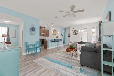 Living area featuring a ceiling fan, light wood-style flooring, a chandelier, and recessed lighting
