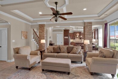 Tiled living room with ceiling fan, brick wall, or