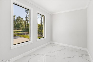 Tiled empty room featuring crown molding