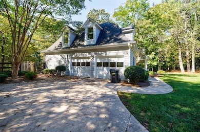 View of property exterior featuring a lawn, drivew