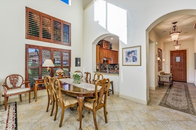 Dining room featuring arched walkways, a high cei