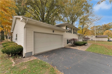 View of side of property with driveway, a yard, and a garage
