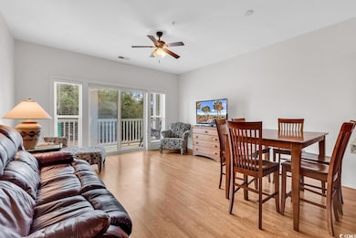 Living area with light wood finished floors and a ceiling fan