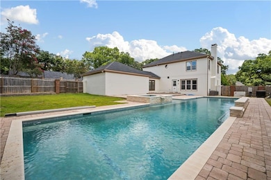 View of swimming pool featuring a fenced backyard, a pool with connected hot tub, and a patio area