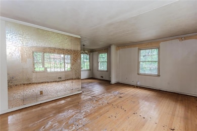 Spare room with hardwood / wood-style flooring, a chandelier, and ornamental molding