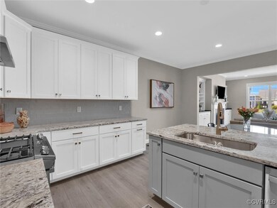 Kitchen with tasteful backsplash, white cabinets,