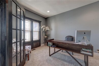 Office with double doors, dark wood window trim an
