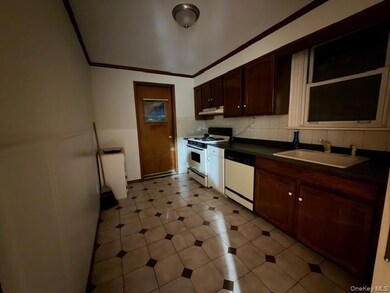 Kitchen with dark countertops, white appliances, dark brown cabinetry, ornamental molding, and backsplash