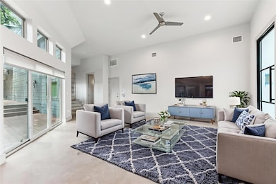 Living area with a ceiling fan, a towering ceilin