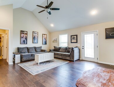 Vaulted ceiling, recessed and ceiling fan lighting, hardwood and an exterior door. Master suite and laundry room down hallway