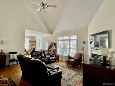 Living room with a ceiling fan, hardwood flooring,