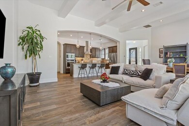 Living room featuring arched walkways, ceiling fa