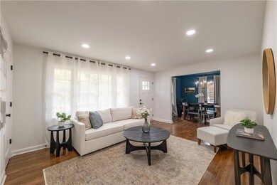 Step through the welcoming blue front door into a stunning and spacious living room flooded with natural light from large windows. Recently refinished hardwood floors create warmth throughout, while can lights provide perfect ambiance for entertainin
