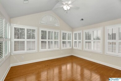 Large Sun Room with Cathedral Ceiling, Custom Plantation Shutters, and Hardwood Floors.