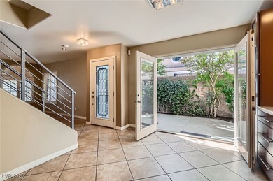 Foyer entrance with light tile patterned floors, s