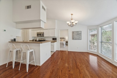 A view of the breakfast bar + bar seating, dining room and kitchen.