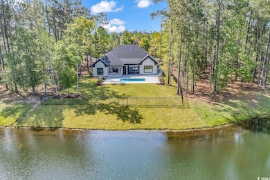 Back of property featuring a water view, a patio a