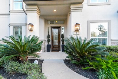 The rich, dark wood front doorway, with its exquisitely etched window design, is welcoming and sophisticated. The stuccoed exterior finish is neat, clean and traditional. The alcoved entry is lit by recessed fixtures from above; provides privacy and shelter from inclement weather and makes home deliveries easy.