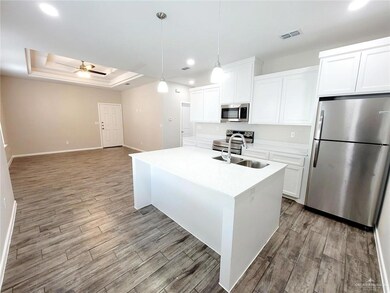 Kitchen featuring appliances with stainless steel finishes, a sink, a ceiling fan, wood finished floors, and recessed lighting