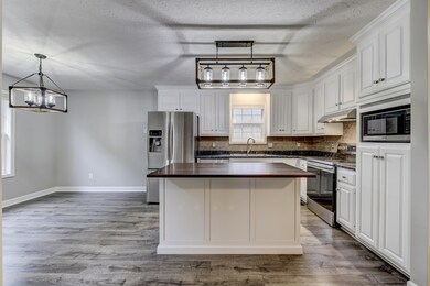 Stainless steel appliances and modern new lighting add just the right touch to this kitchen and eating area!
