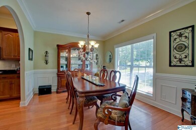 features hardwood floors, crown molding, and wainscoting. The space opens directly into the kitchen for an ideal flow when serving large family meals.