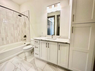 Full bathroom with toilet, vanity, and tiled showe