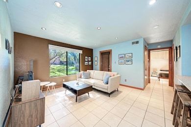 Living room with light tile patterned floors and recessed lighting