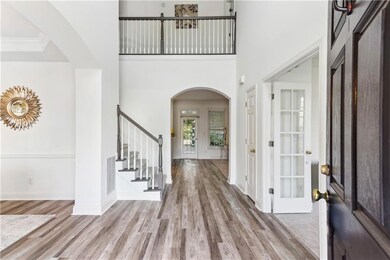 Foyer with arched walkways, wood finished floors, 