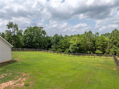 Fenced backyard with a forest view
