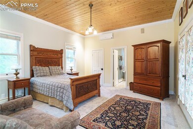Bedroom with wood ceiling, light carpet, multiple windows, ornamental molding, and a wall unit AC
