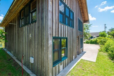 View of side of property with board and batten siding, a patio, and a lawn