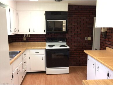 FRESHLY PAINTED CABINETRY & LAMINATE FLOORING IN T