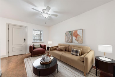 Living room featuring ceiling fan and light hardwo