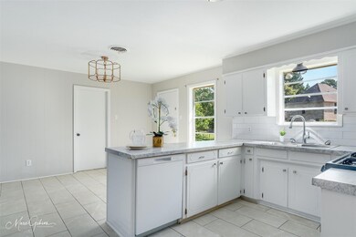 Kitchen with dishwasher, sink, tasteful backsplash