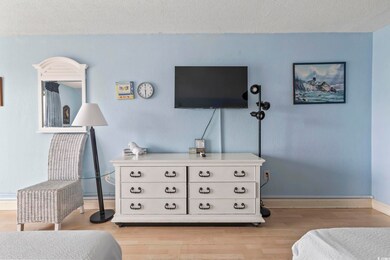 Bedroom featuring a textured ceiling, light wood-type flooring, and baseboards