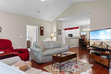 Living room featuring dark hardwood / wood-style floors, a chandelier, and high vaulted ceiling