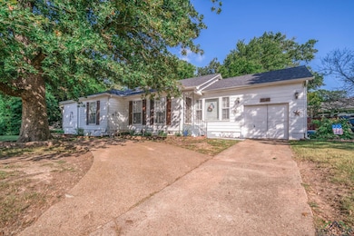 Single story home featuring concrete driveway, a garage, and crawl space