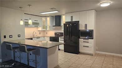 Kitchen with black appliances, a Quartz peninsula,