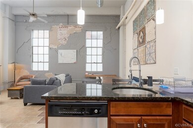 Kitchen featuring tile floors, natural light, a ceiling fan, dishwasher, dark countertops, and pendant lighting