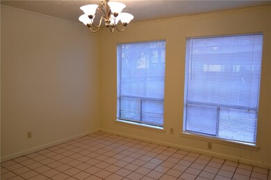Unfurnished room featuring crown molding, baseboards, and a notable chandelier