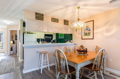 Dining room with an inviting chandelier, hardwood 