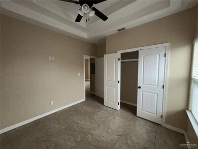 Unfurnished bedroom with a raised ceiling, baseboards, a closet, and ceiling fan