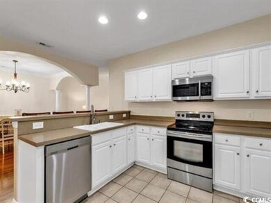 Kitchen featuring arched walkways, a notable chand