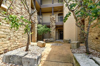 Property entrance featuring a balcony, stucco sid