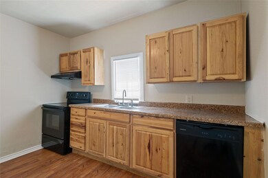 Kitchen featuring sink, hardwood / wood-style floors, and black appliances
