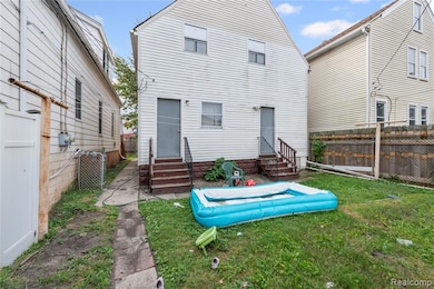 Back of house featuring entry steps and a fenced backyard