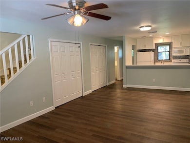 Living room featuring ceiling fan, dark hardwood /
