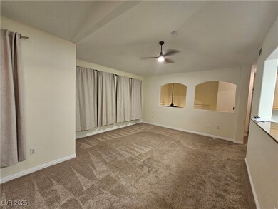 Carpeted empty room featuring a ceiling fan and ba