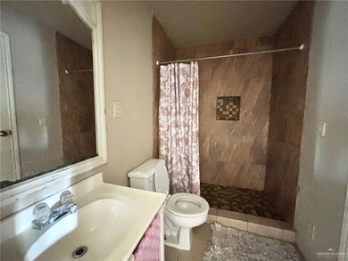 Bathroom featuring vanity, toilet, tile patterned floors, and walk in shower