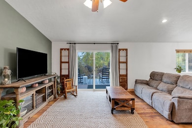 Living area with light wood finished floors, a ceiling fan, and a textured ceiling